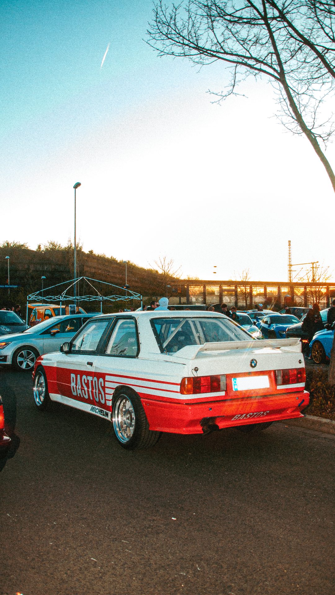 Klassischer BMW in Weiß-Rot bei Sonnenuntergang.